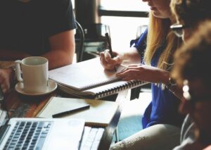 Marketingteam in einem Meeting, das gemeinsam an Ideen, Notizen und Laptop arbeitet.